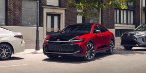 A red and black Toyota vehicle with other cars visible in the background.