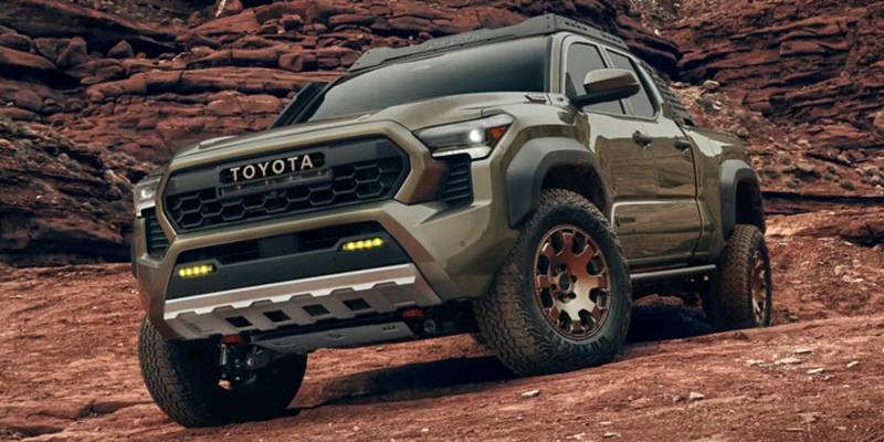 A Toyota truck parked on rocky terrain, showcasing its rugged off-road design.