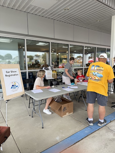 Car show registration table at a community event.